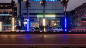 A multi-story hotel with illuminated signage, a prominent entrance, and a modern architectural design. - Lam Giang Hotel (Thanh Vinh)