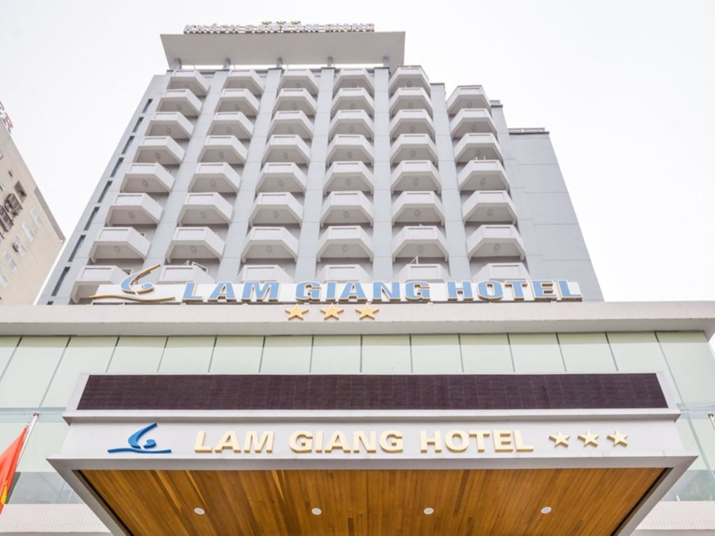 L’extérieur de l’hôtel Lam Giang se distingue par son architecture moderne, ses nombreux balcons et une enseigne bien visible.