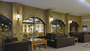 A lobby with leather seating, a glass coffee table, and ornate wall decorations. - Balikcilar Hotel (Konya)