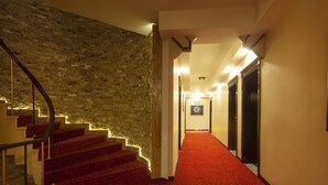 A staircase with red carpet leading to a hallway with a framed picture on the wall. - Balikcilar Hotel (Konya)