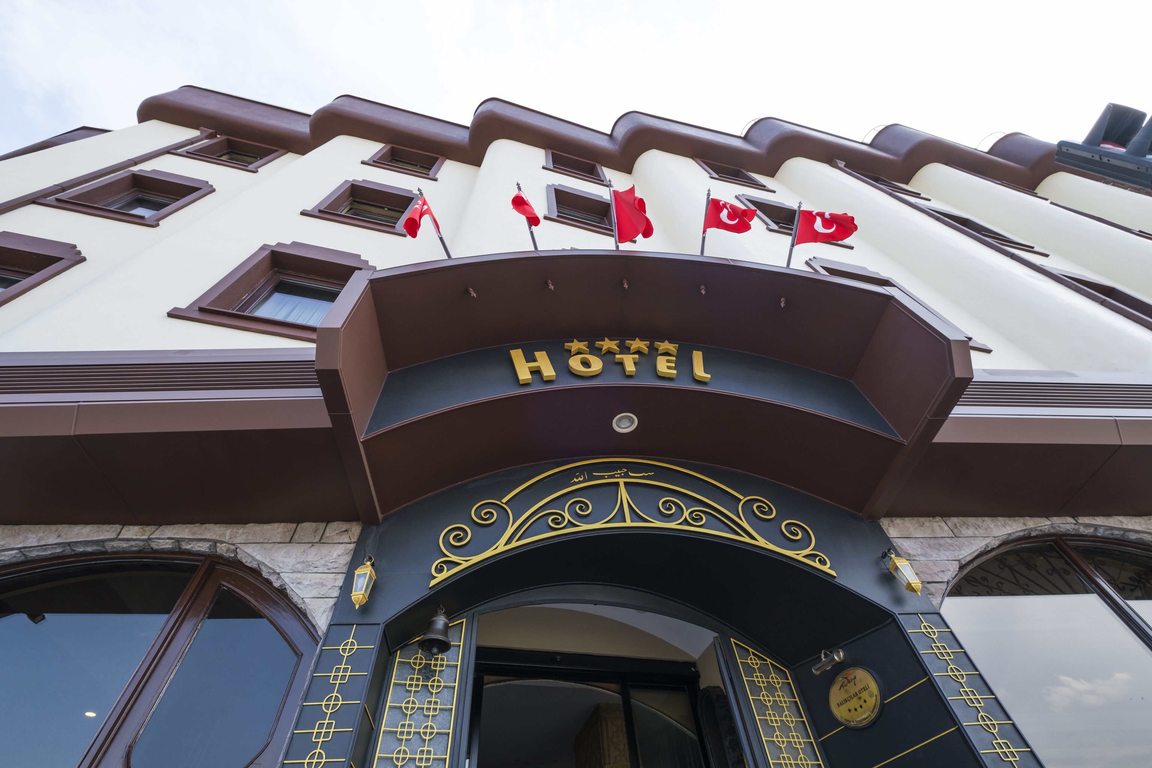 A hotel entrance with a sign reading "HOTEL" and multiple flags.