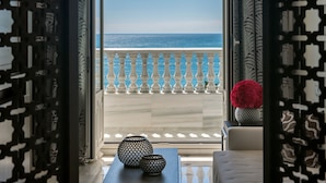 A balcony with a view of the sea, patterned curtains, and decorative vases. - Gran Hotel Miramar GL (Málaga)