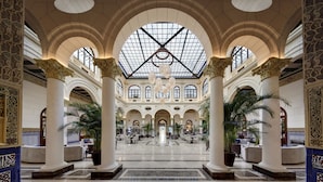 A spacious lobby with high ceilings, large windows, and ornate columns. - Gran Hotel Miramar GL (Málaga)