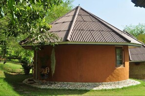 Un petit bâtiment d’un seul étage, à l’extérieur brun et doté d’un toit en tôle ondulée.