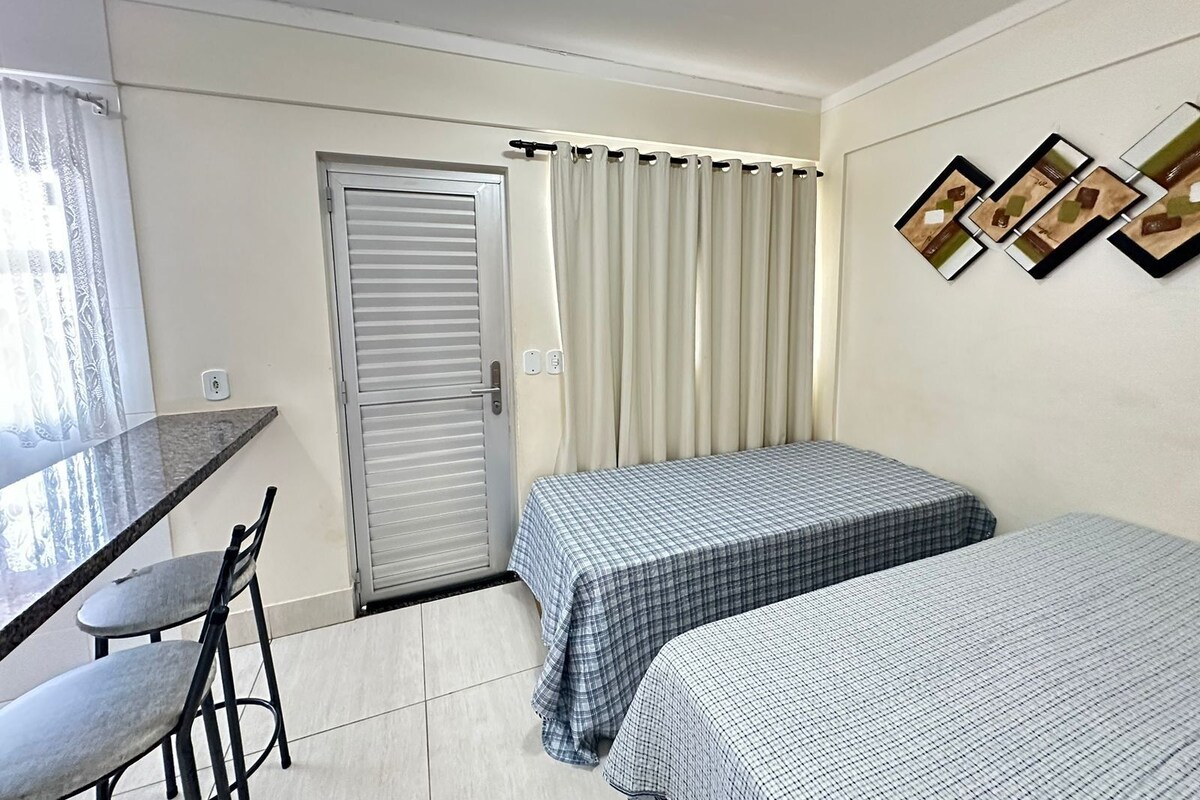 Una habitación pequeña y limpia con una cama, un escritorio y una silla.