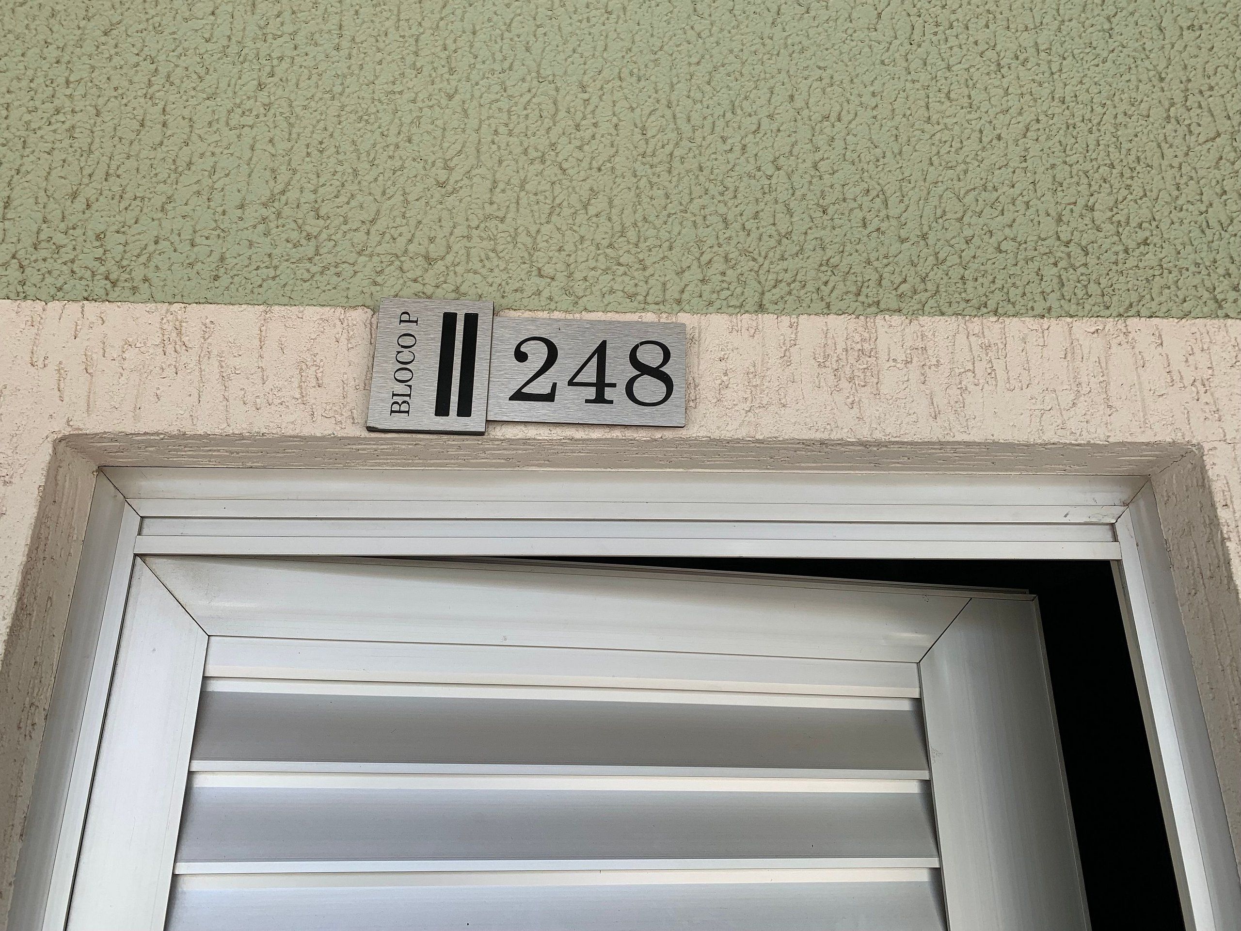 A building entrance with a metal sign displaying 'BLOCOP 248' above a white-framed door.