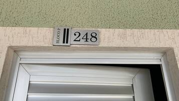 A building entrance with a metal sign displaying 'BLOCOP 248' above a white-framed door.