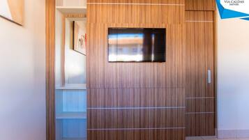 A modern wardrobe with a built-in mirror and a logo for VIA CALDAS IMÓVEIS.