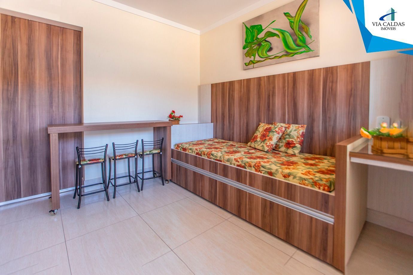 A compact room with a bed, a small table, and two chairs.
