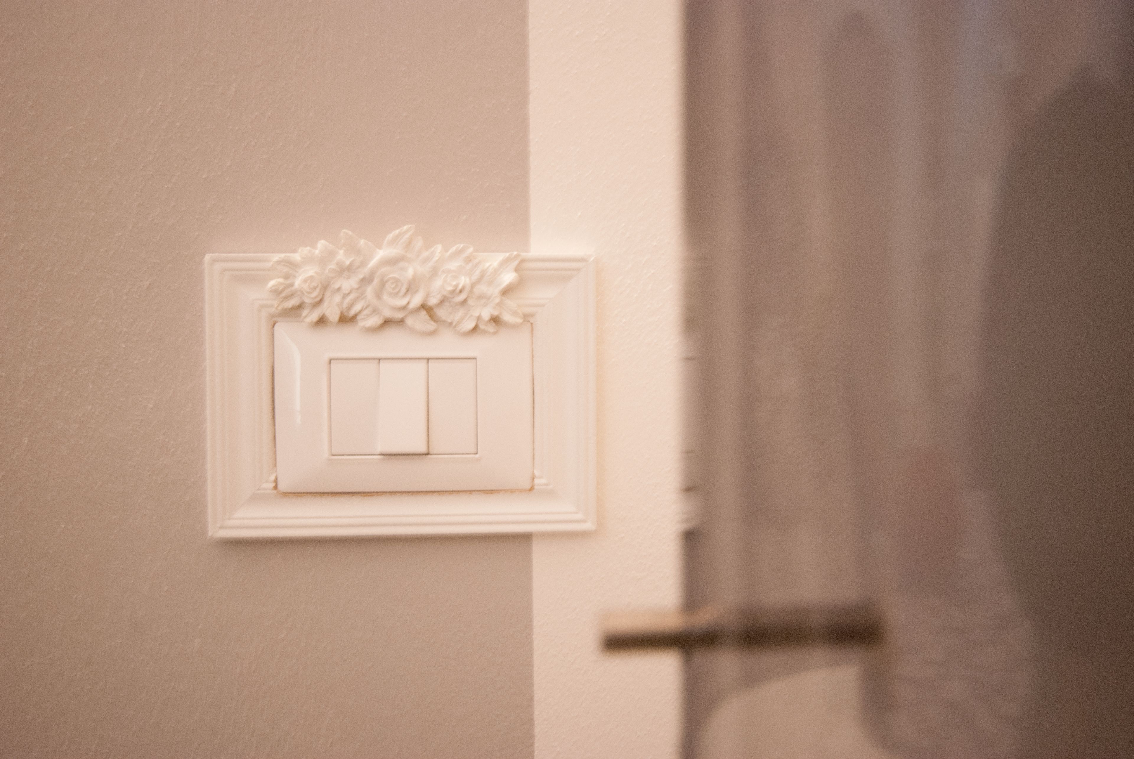 Een bloemenmotief op een lichtschakelaar die aan de muur is bevestigd.