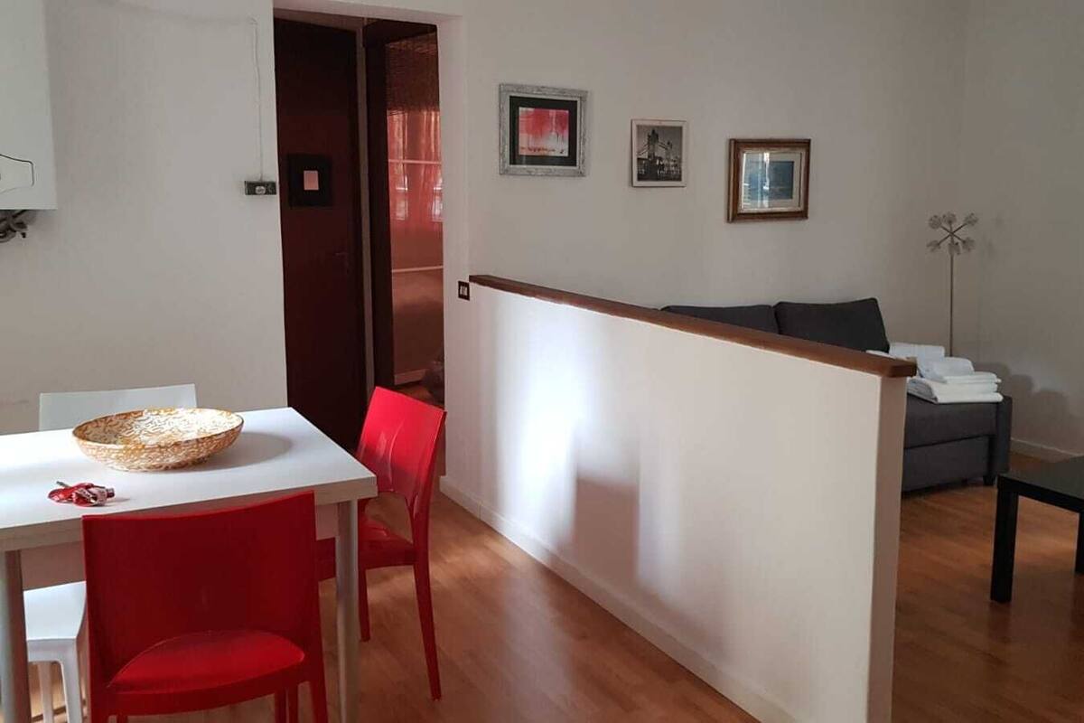 Ein modernes Wohnzimmer mit einer Couch, einem Esstisch mit Stühlen und einem kleinen Tisch.