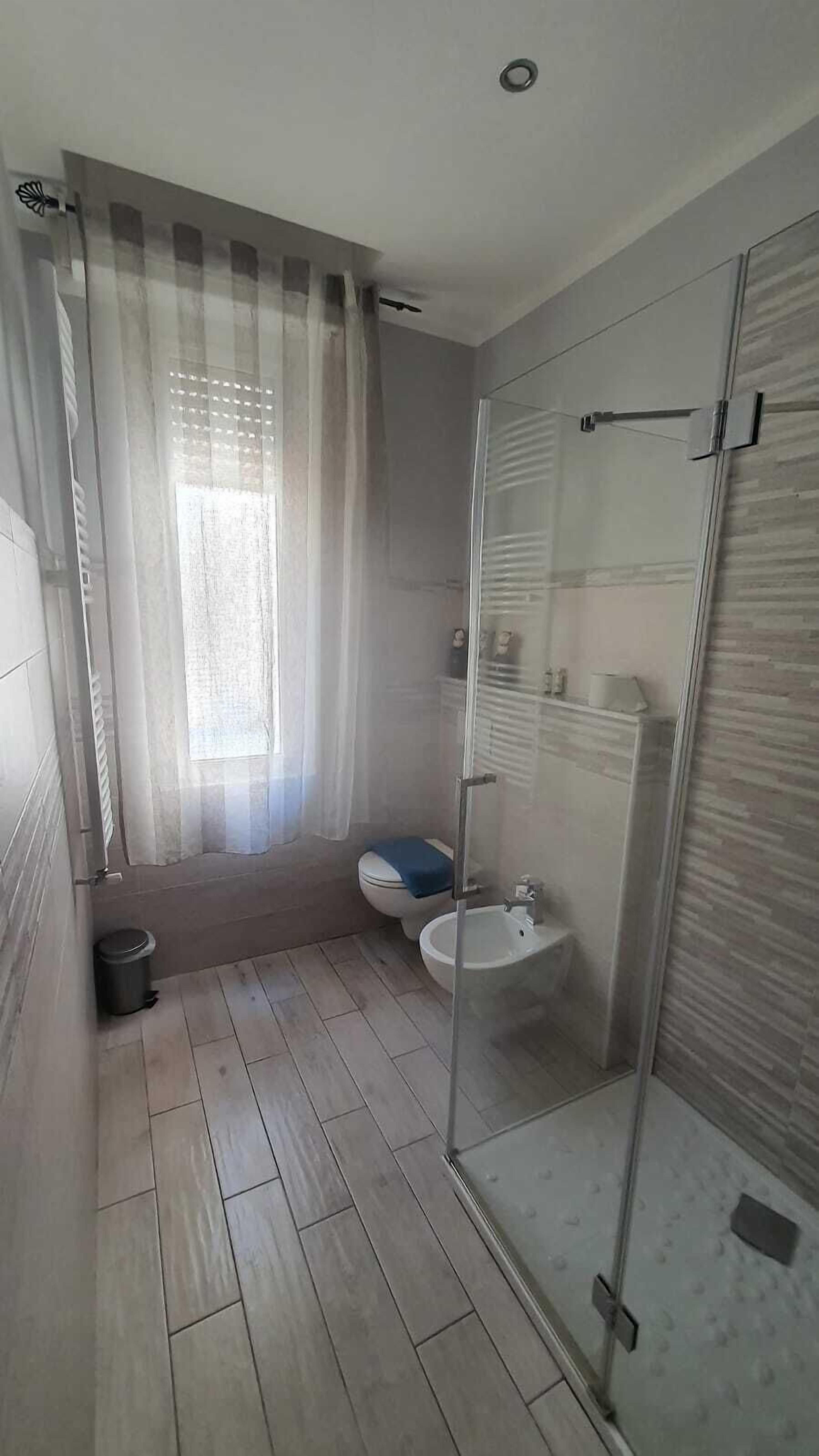 Un baño con cabina de ducha, inodoro y bidé.