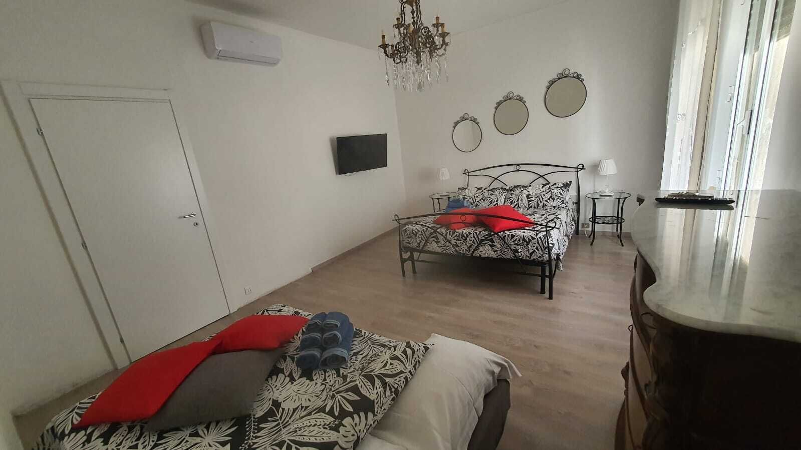 Un dormitorio con dos camas, una araña y un televisor.