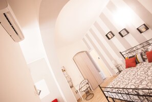 Une chambre à coucher comprenant un lit, une chaise, un bureau et un appareil de climatisation.