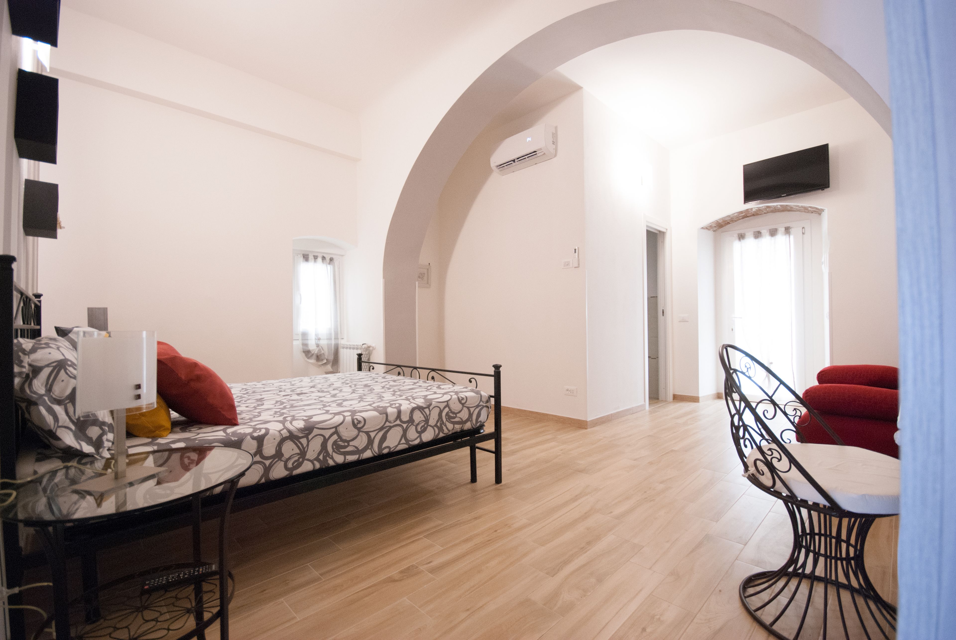 Un dormitorio con cama, escritorio, silla y techo abovedado.