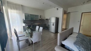 A modern apartment with a dining area, kitchen, and living room.