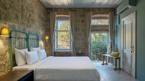 A bedroom with a bed, two windows, a bench, and a door. - Ida Blue, Adatepe - Adults Only (Ayvacik)