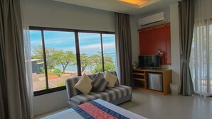 Une chambre d’hôtel avec un lit, un canapé, une télévision et une vue sur l’extérieur.