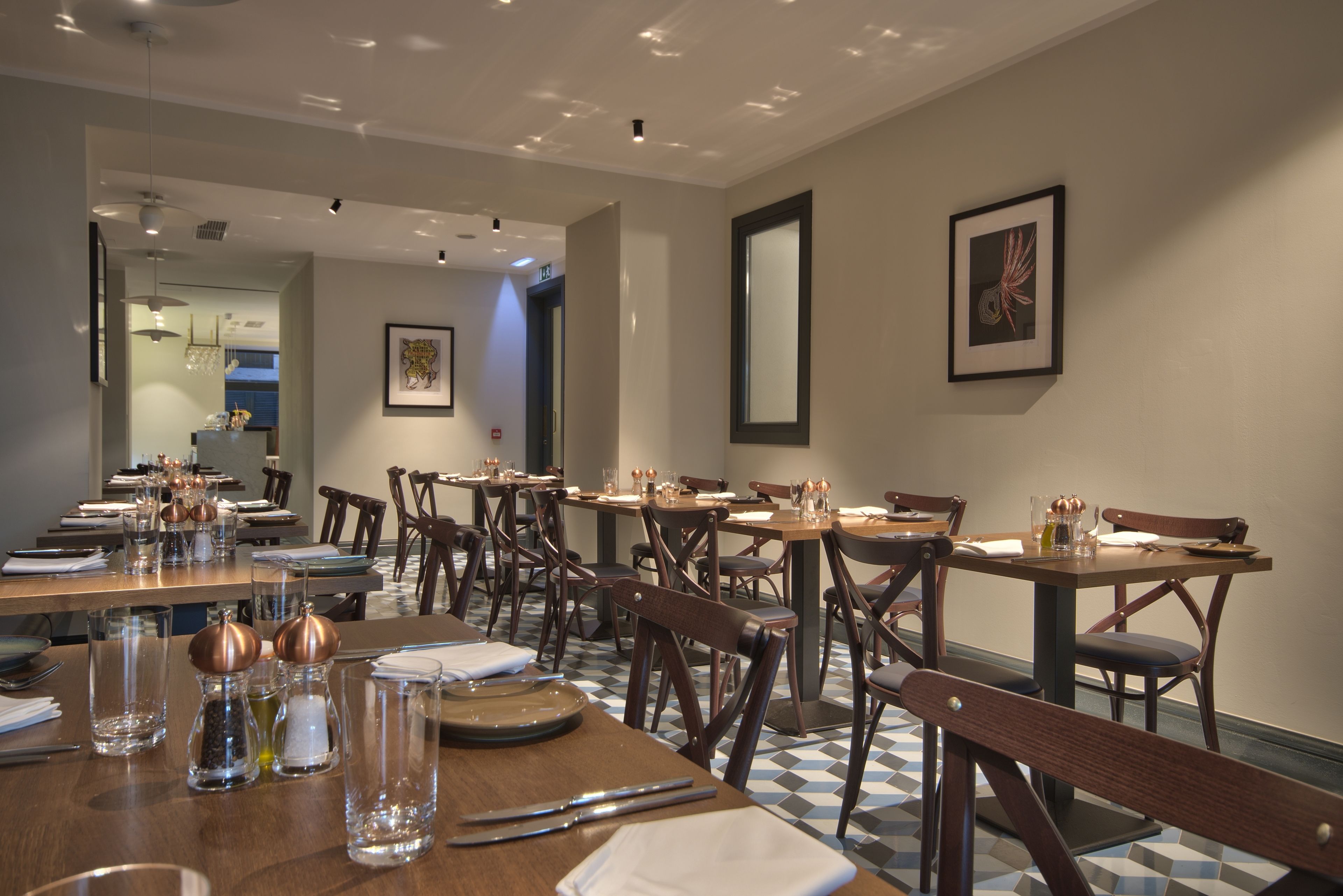 A dining area with multiple tables and chairs, arranged in a spacious layout.