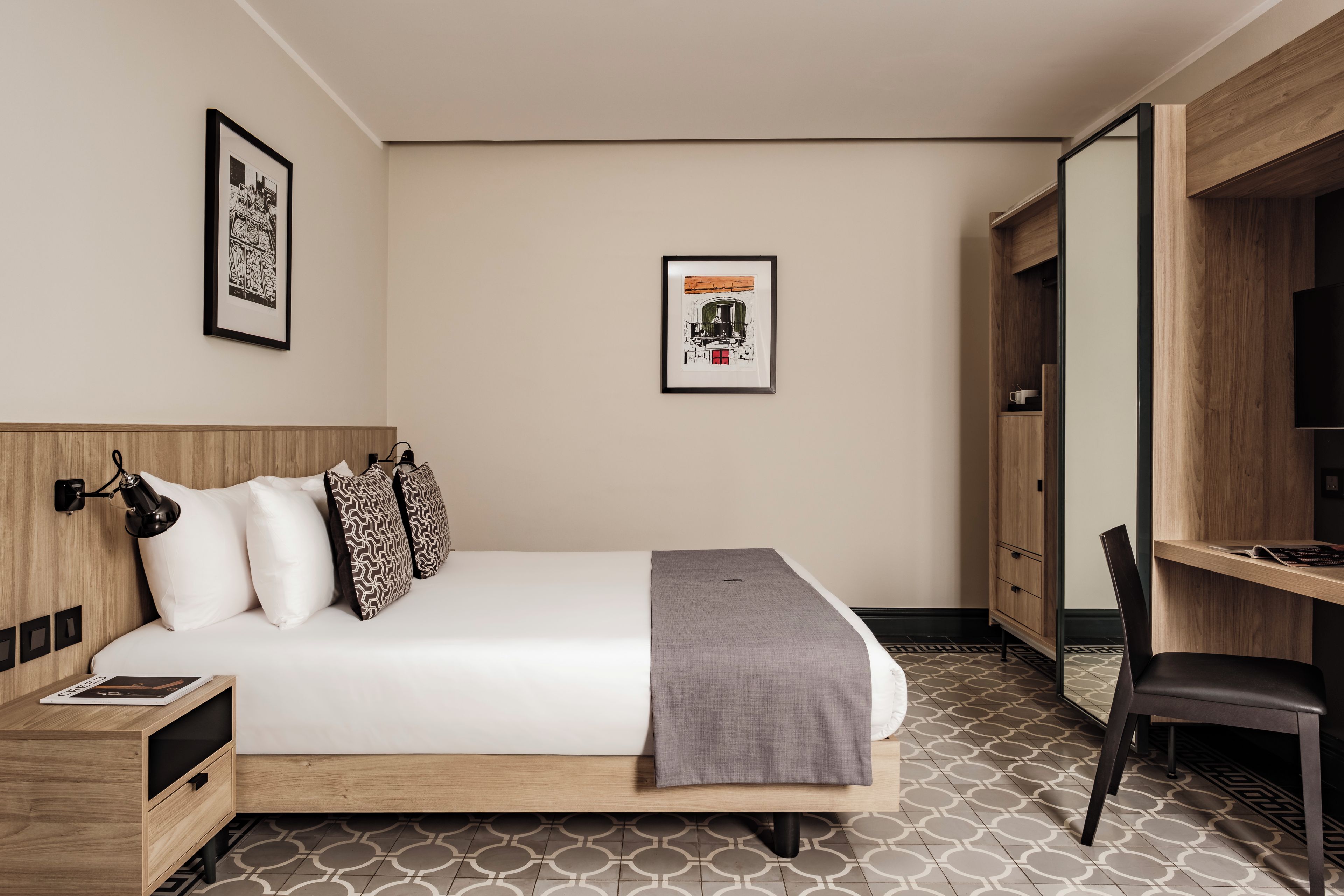 Ein Hotelzimmer mit einem Bett, einem Schreibtisch, einem Stuhl und einem Kleiderschrank.
