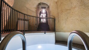 Une piscine dotée d’une rambarde en métal, d’un escalier menant à un niveau supérieur et d’un mur à texture.