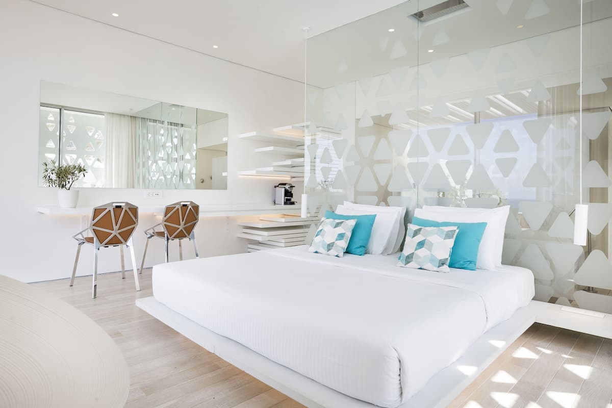 Un dormitorio moderno con una cama grande, un escritorio y sillas.