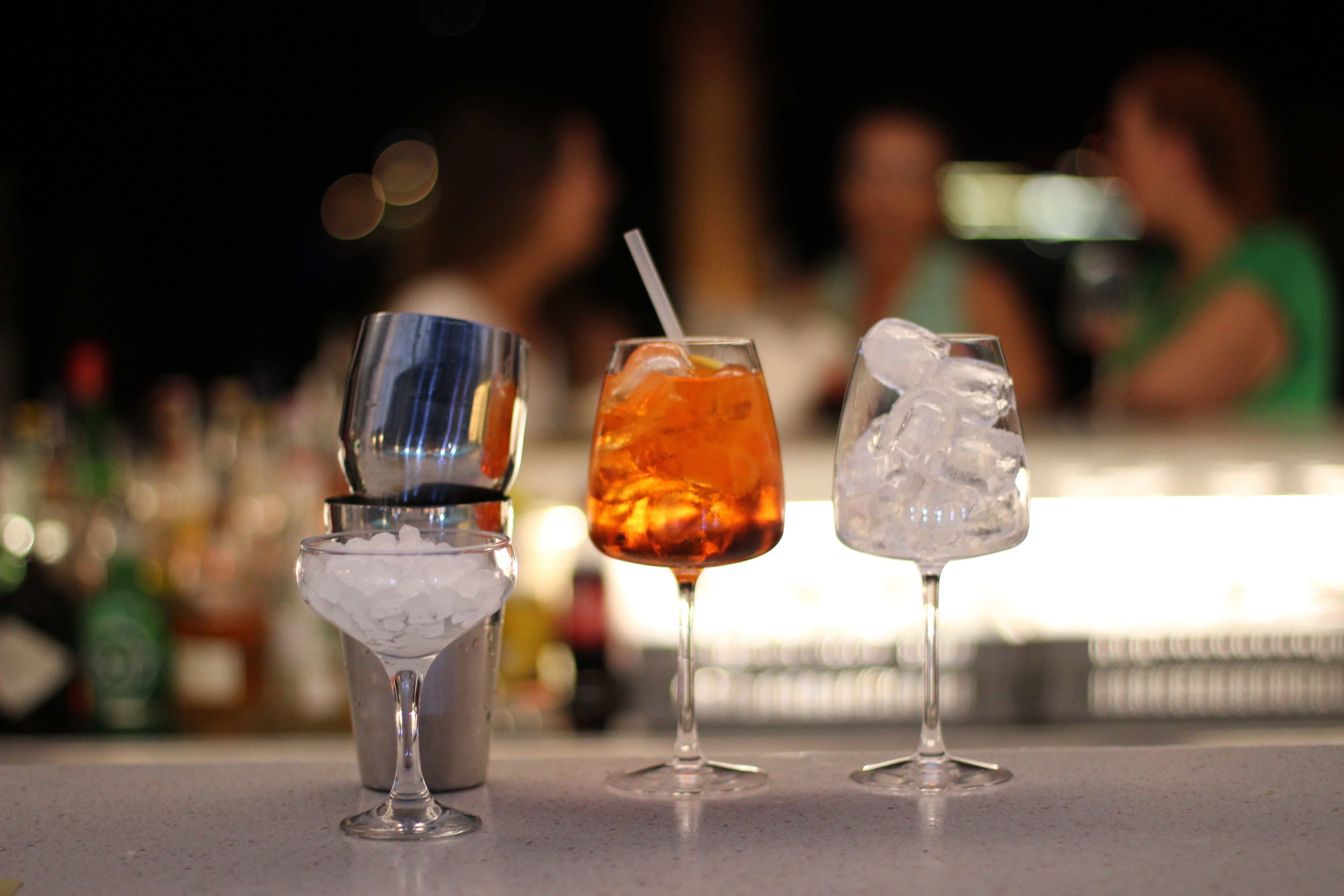 Tres vasos de bebidas diferentes sobre una barra.