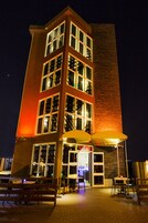 Um edifício com vários andares, destacando-se por uma torre de tijolos e grandes janelas.