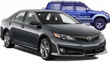 Um sedan preto com o logotipo Toyota visível na grade dianteira.