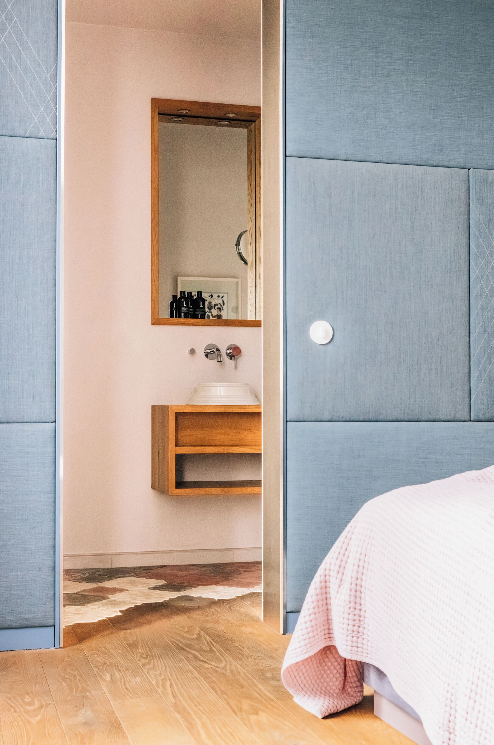 Un baño moderno con tocador de madera, espejo y lavamanos.