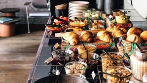 Una mesa de buffet con diversos alimentos y utensilios.