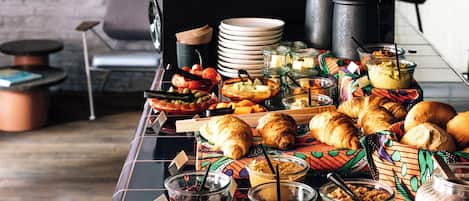 Una mesa de buffet con diversos alimentos y utensilios.