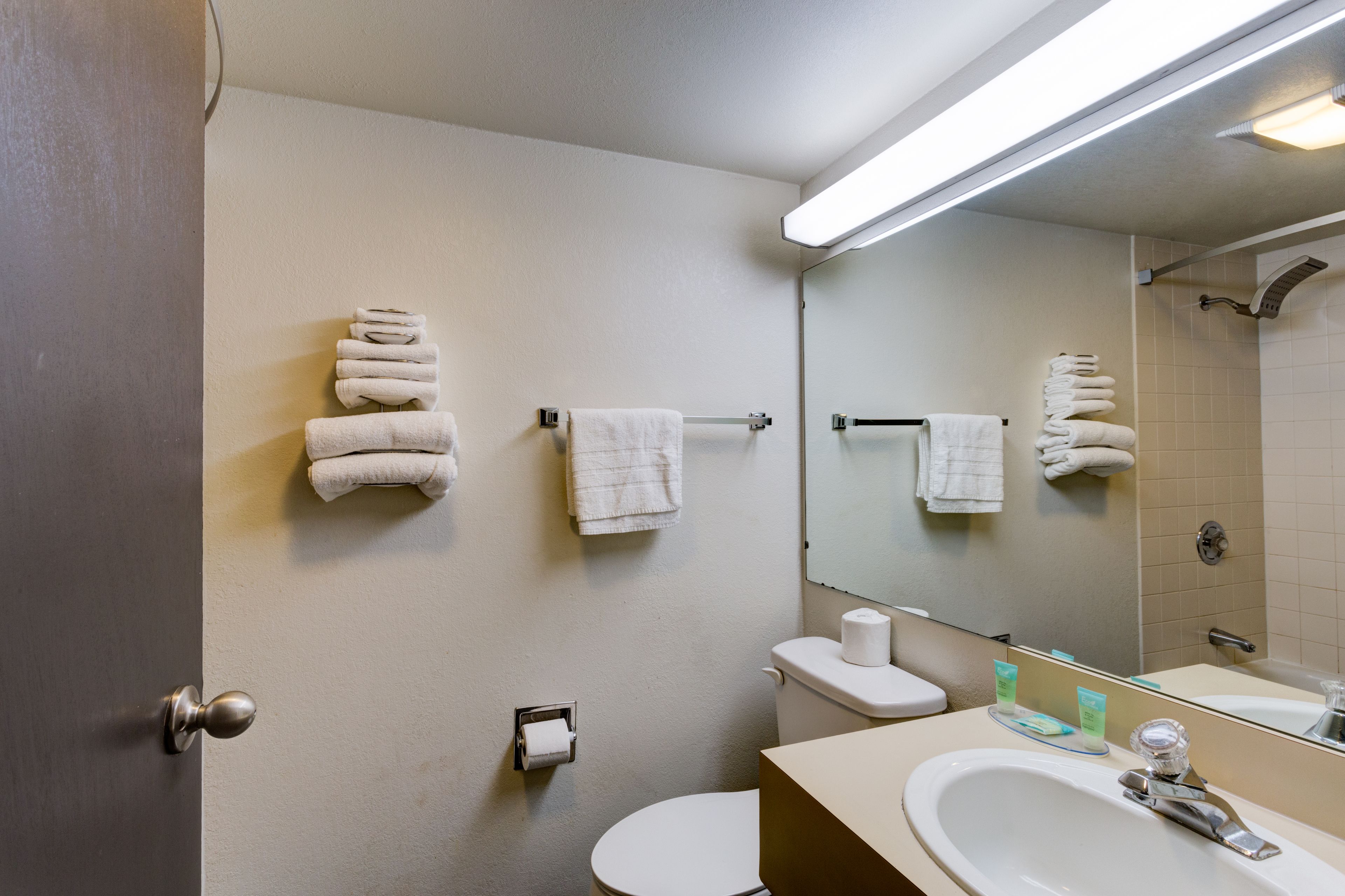 A bathroom with a toilet, sink, and towel rack.