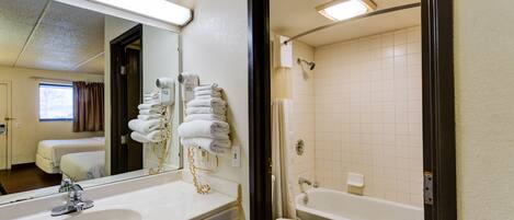 A hotel bathroom with a sink, toilet, and bathtub.