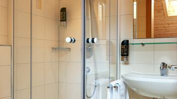 Un bagno moderno con doccia vetrata, lavabo bianco e water.