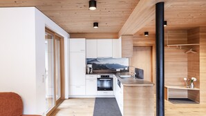 Une cuisine moderne avec des meubles en bois, un four encastré et une grande fenêtre donnant sur un paysage pittoresque.