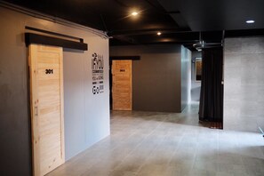 Ein Flur mit zwei Türen, die mit 301 und 303 beschriftet sind, Holzdielen und einem modernen Interieur.