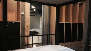 A hotel room with a bed, a wardrobe with multiple compartments, and a door leading to another room. - Marktel&Coffee - Hostel (Chiang Mai)