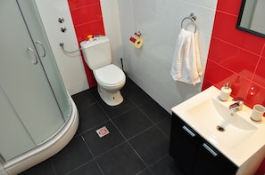 A bathroom with a toilet, a sink, and a shower.