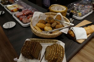 Un bufé con diversos alimentos, como pan, pasteles y embutidos.