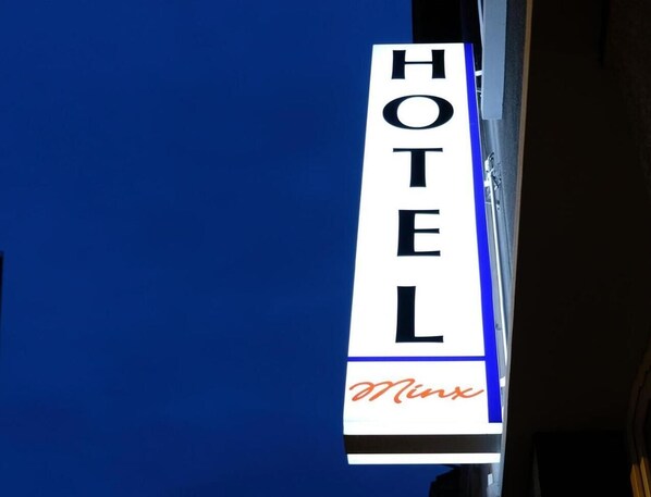Un letrero de hotel con la palabra 'HOTEL' y el nombre 'Minx' en cursiva.