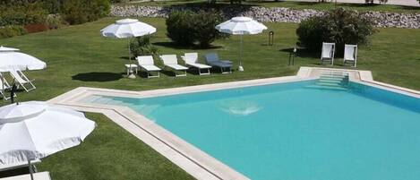 Alberca al aire libre por temporada y sombrillas en la alberca