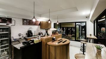 Una cocina moderna con una isla central, electrodomésticos de acero inoxidable e iluminación colgante.
