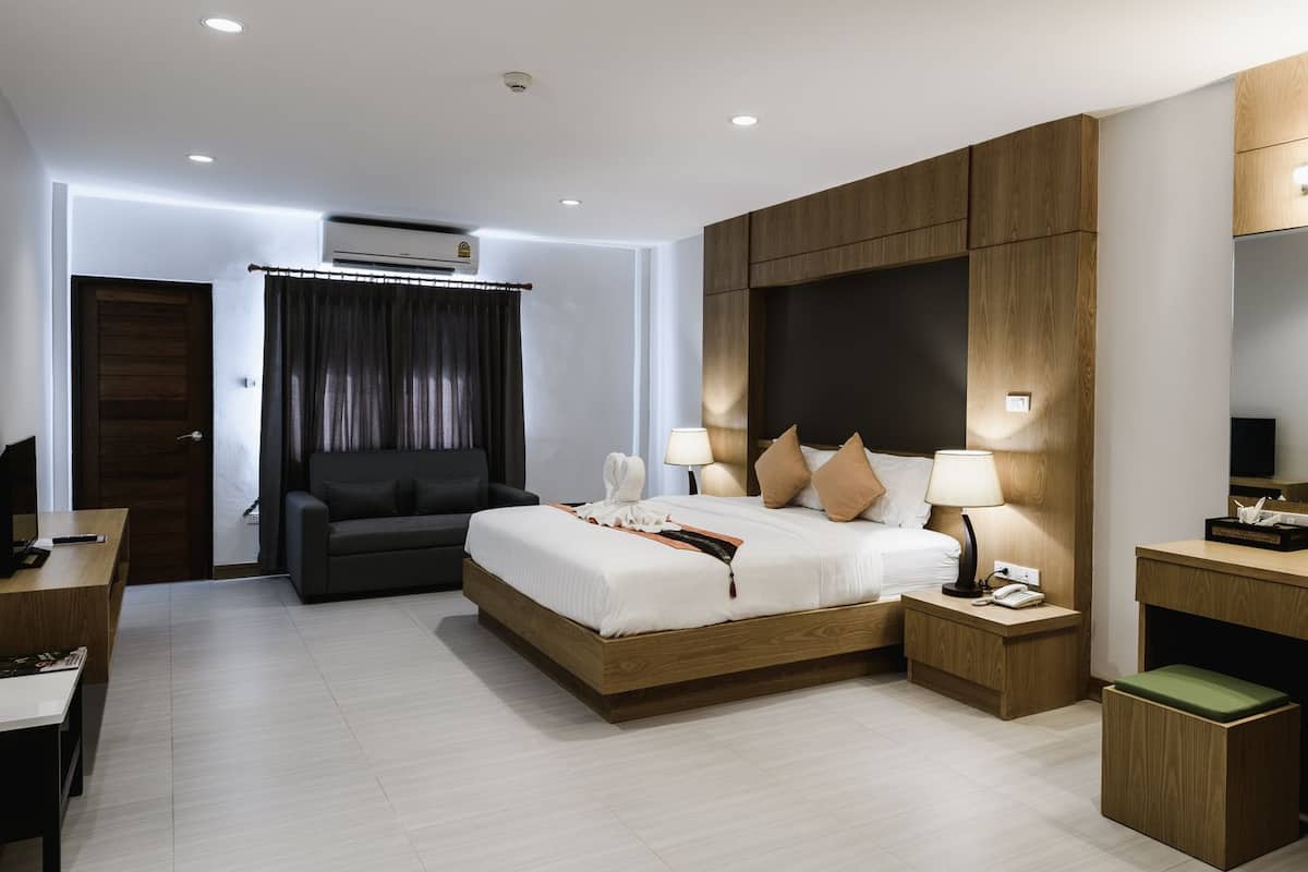 Een moderne hotelkamer met een groot bed, nachtlampjes, een bureau en een televisie.