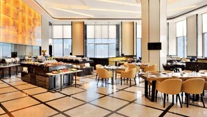 A spacious hotel dining area with a buffet, multiple tables, and chairs. - Radisson Blu Coimbatore (Coimbatore)