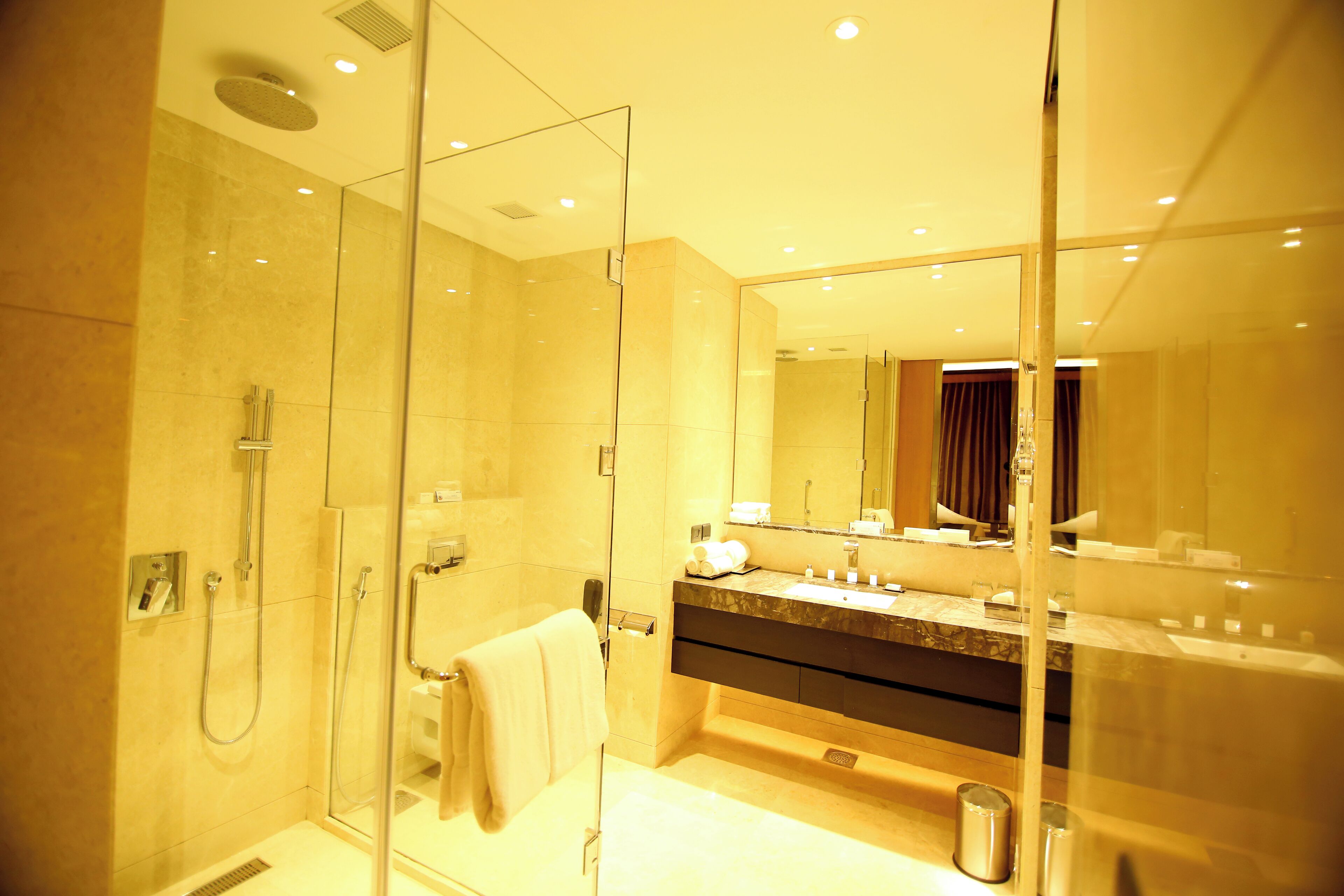 A modern bathroom with a glass shower enclosure, a vanity with a mirror, and a bathtub.
