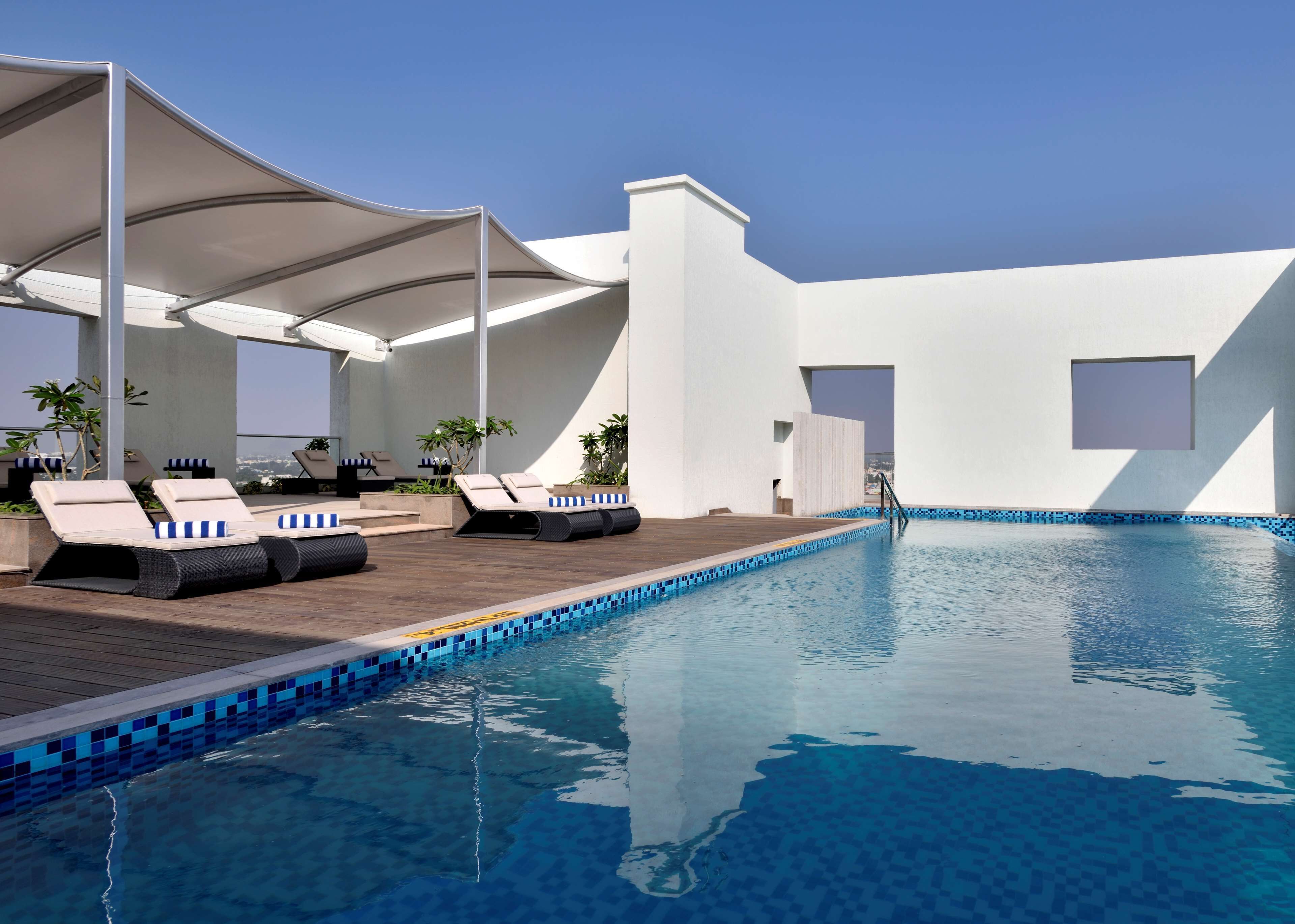 Una piscina al aire libre, sillones reclinables de piscina