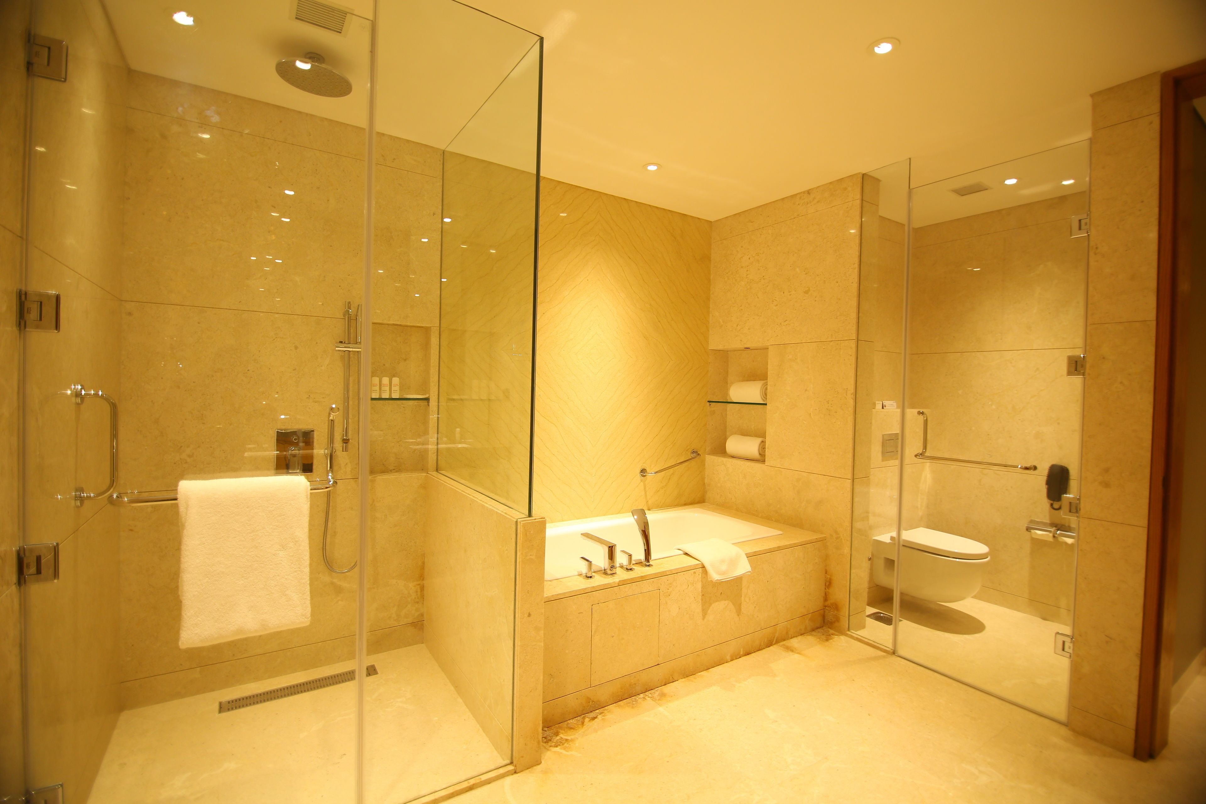 Un baño moderno con ducha acristalada, bañera y retrete.