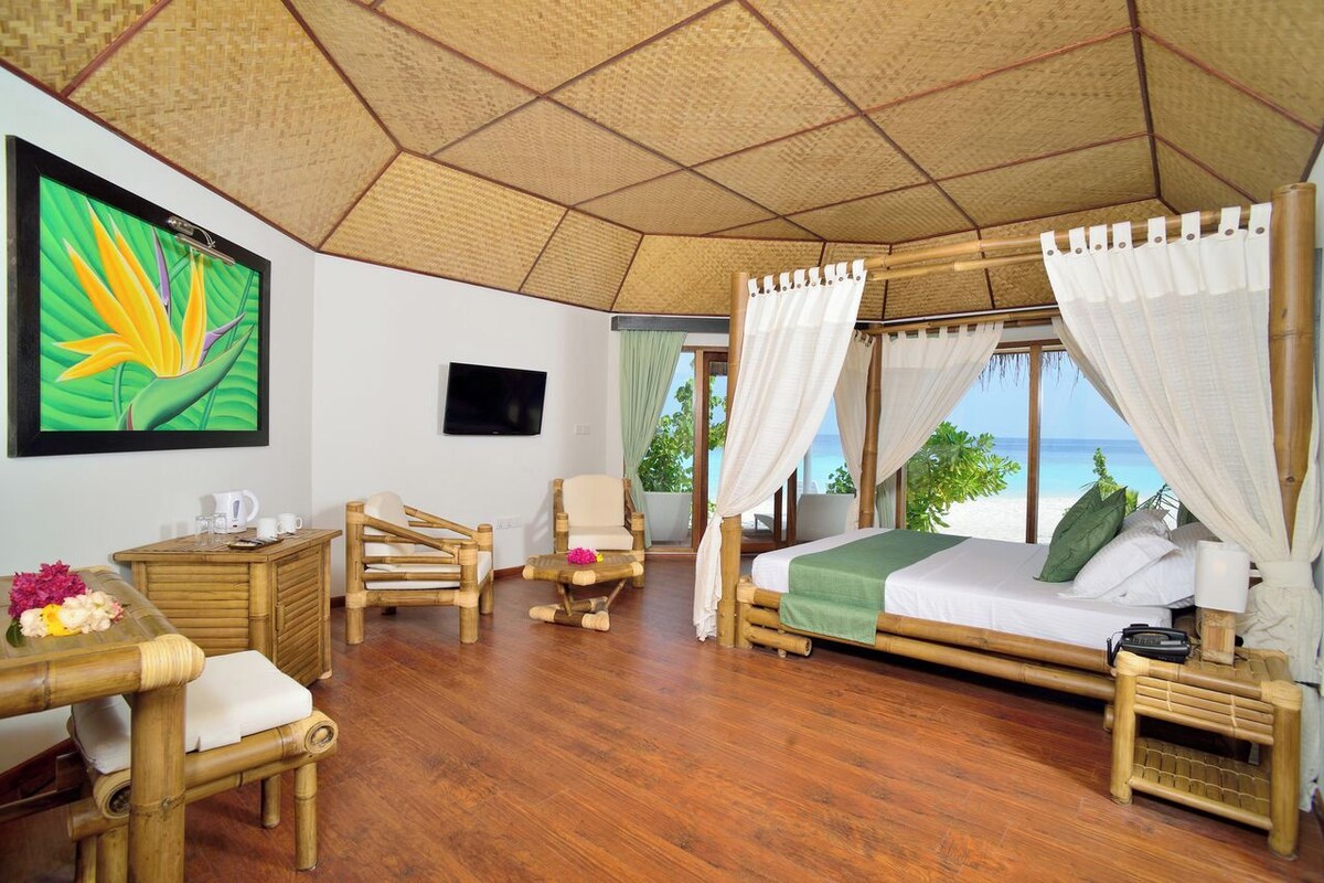 A room with a bed, a desk, a chair, and a TV.