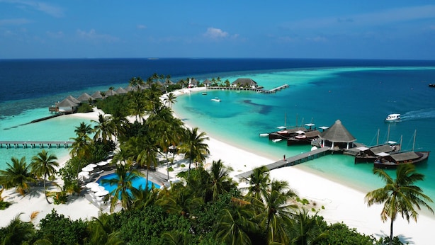 A tropical resort with overwater bungalows, a swimming pool, and a pier extending into the turquoise sea. - Safari Island Resort (Mushimasgali)